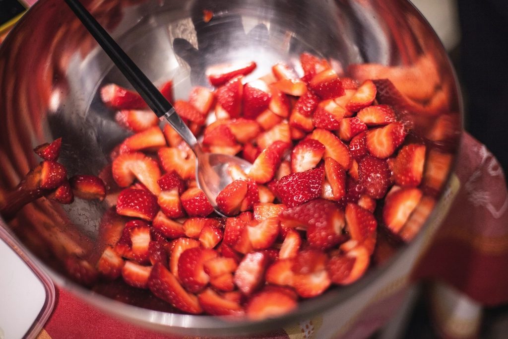 Ross stirring a copper pot of bubbling jam on the stove